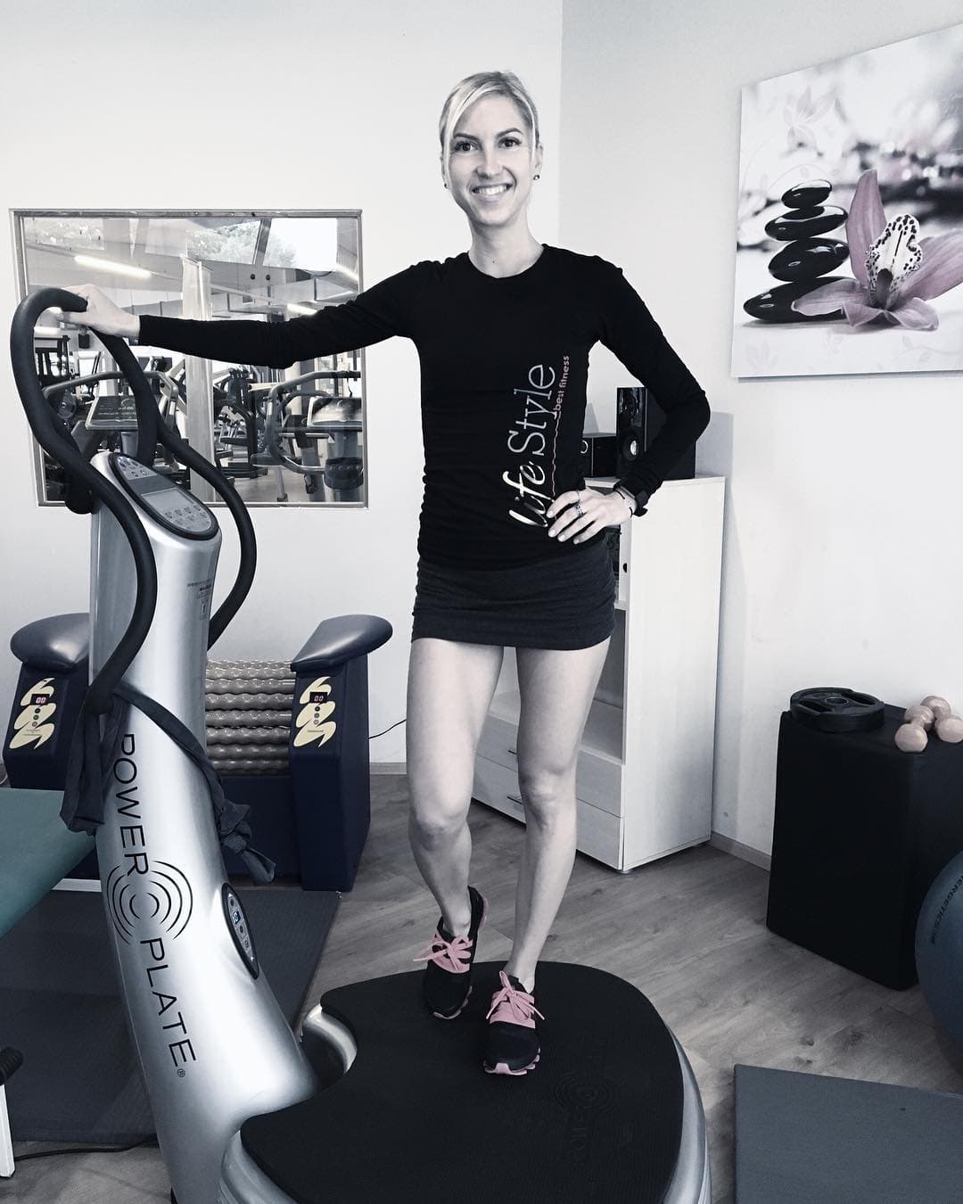 Trainer on Vibration Plate in Gym Fitness trainer standing on a vibration plate machine in a gym studio.
